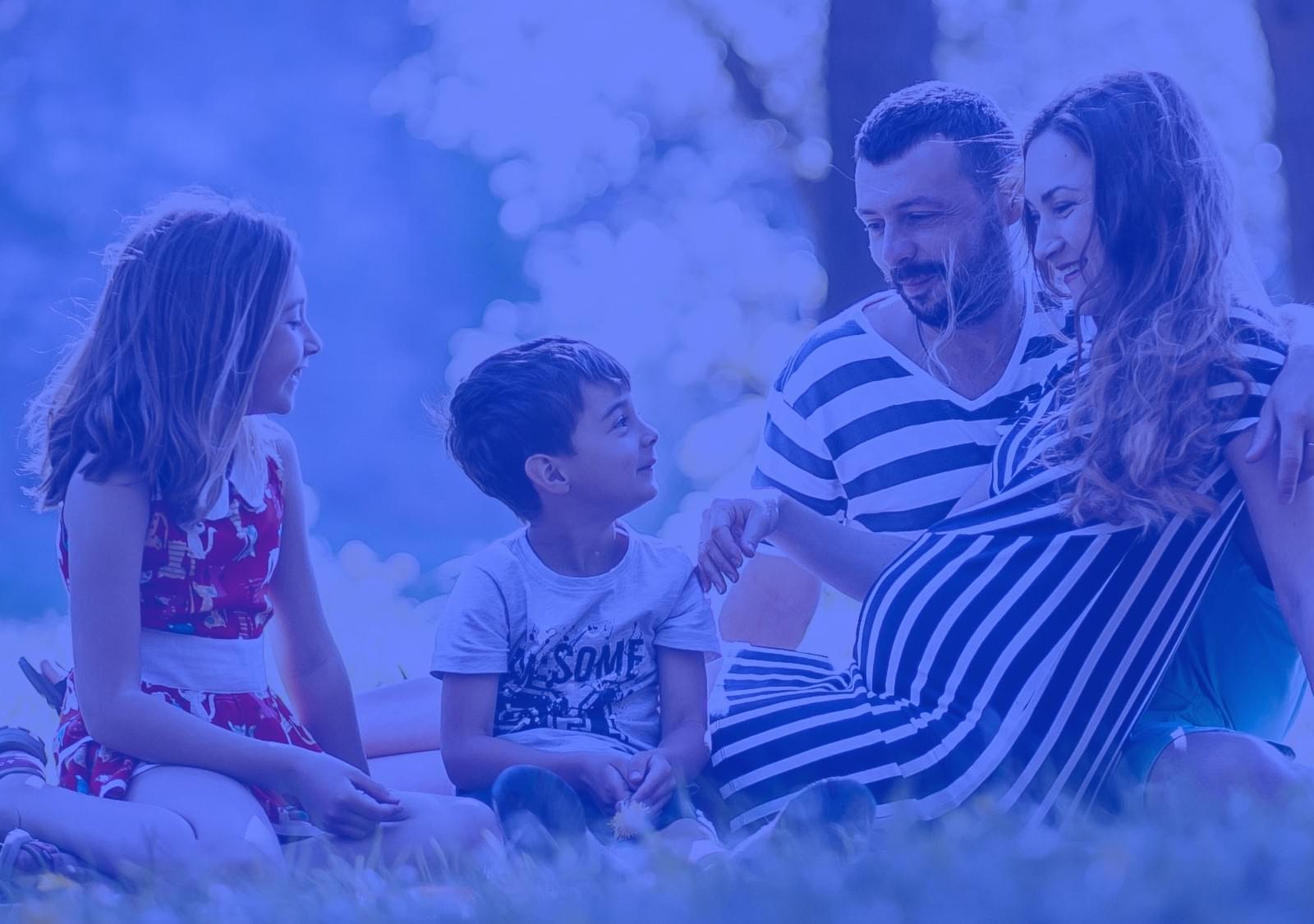 A family sitting together outside in the grass